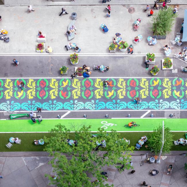 Overhead view of brightly-colored urban garden painted on the street. 