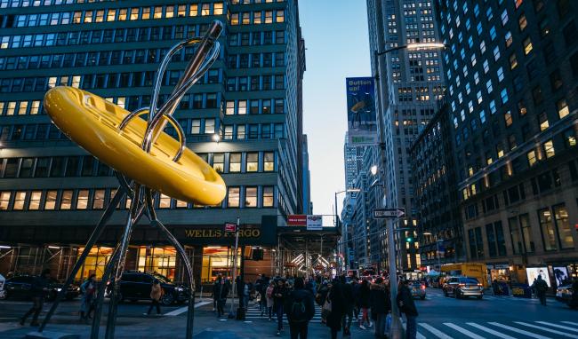 The new Big Button, yellow, with people walking by on 7th avenue. 