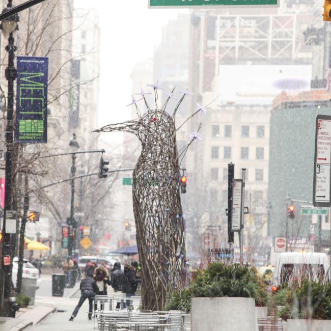 wide shot of a large sculpture of a bird constructed from sticks