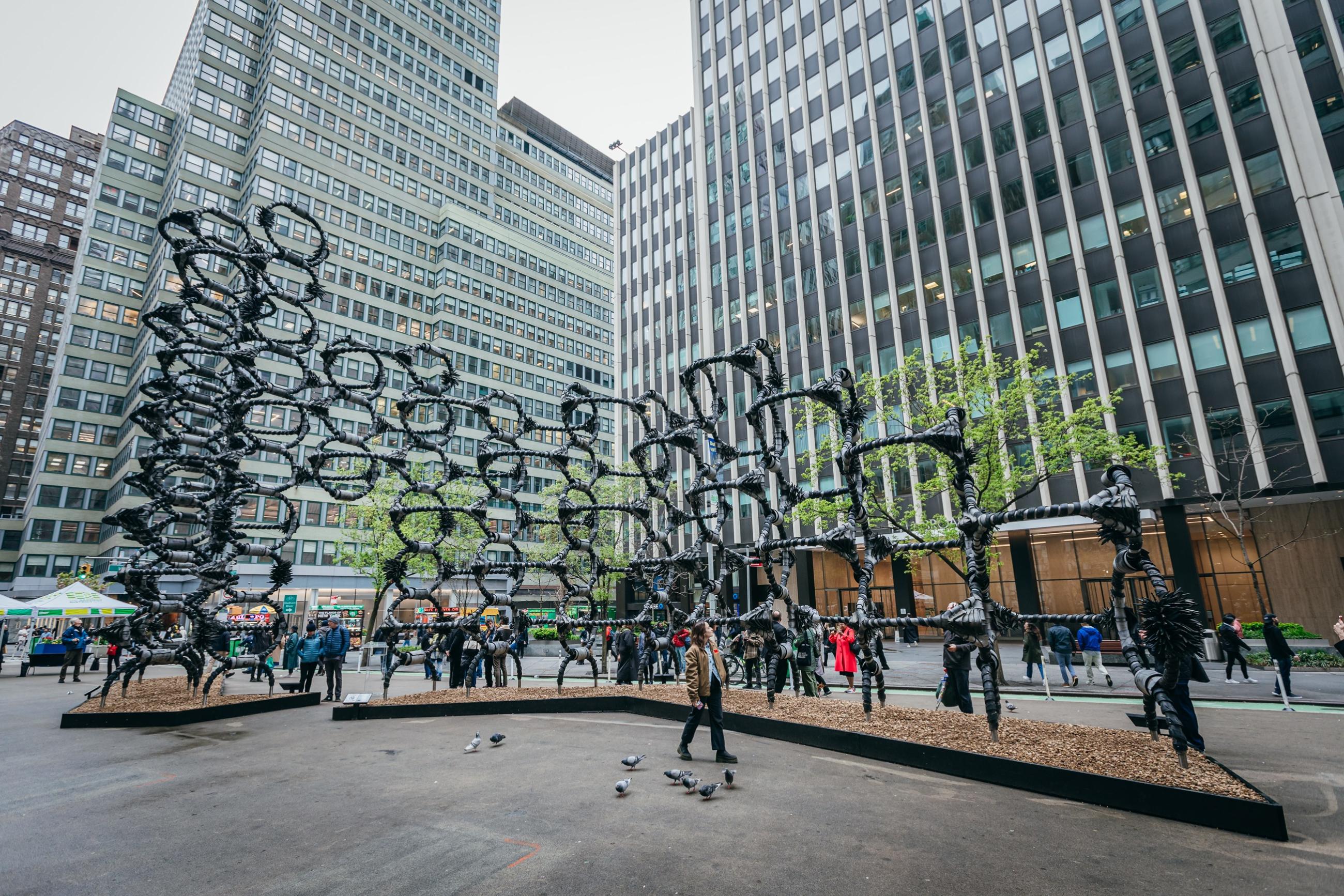 A large geometric structure made of  a latticework of interconnected steel bars wrapped artistically with strips of old tires. 